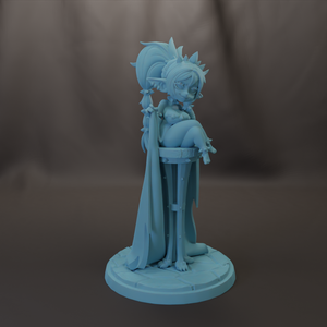 A light blue figurine of a female character with a large headdress and long flowing hair, sitting on a pedestal.