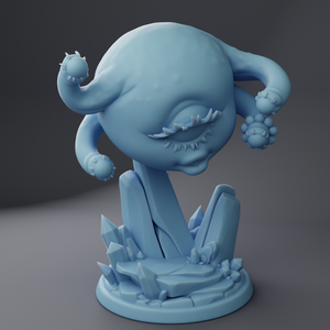 a blue figurine of an alien sitting on a rock