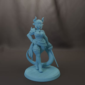 A figurine of a woman with horns, wearing a dress and holding a sword, standing on a platform.