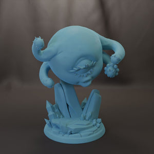 A blue, abstract sculpture with a large, round head and a smaller, round body. The sculpture appears to be made of a material that resembles stone or crystal, giving it a unique, organic-looking appearance.