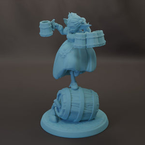 A light blue figurine of a person holding a mug and standing on a barrel.