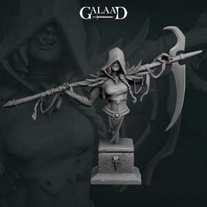 A statue of a female warrior figure holding a large weapon and wearing a hooded cloak, with the text "GALAAD" above the statue.
