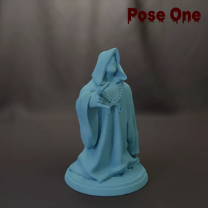 A light blue statue of a figure with a hooded cloak and a chain around its neck, standing on a base.