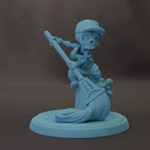 A light blue figurine of a skeleton holding a broom and standing on a platform.