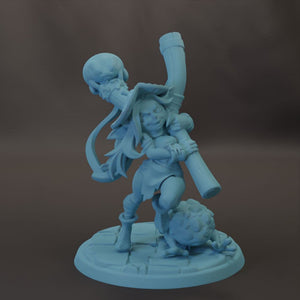 A figurine of a woman with a large pipe in her hand, standing on a platform.