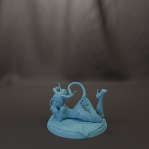 A light blue figurine of a mermaid or sea creature is depicted in a relaxed pose, lying on its back with its head resting on its hand.