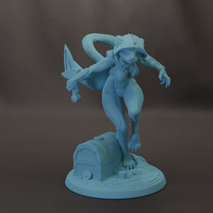 A blue figurine of a person holding a sword and standing on a chest.
