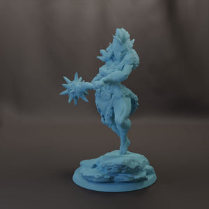 A figurine of a warrior wielding a large weapon, standing on a rock formation.