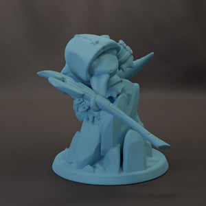 A light blue figurine of a person holding a weapon, standing on a rock formation.