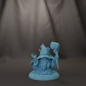 A blue figurine of a wizard or magical being holding a staff and standing on a platform.
