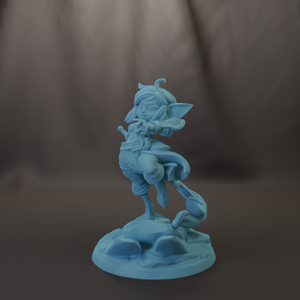 A light blue figurine of a whimsical, fantastical creature with horns and wings, standing on a rock formation against a dark background.