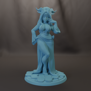 A blue statue of a woman with horns, standing on a platform and holding her hand to her face.