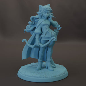 A figurine of a female character with long hair and a flowing cape, holding a bow and arrow, standing on a base.