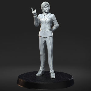 A 3D model of a person wearing a suit and tie, standing on a black base and gesturing with one hand.