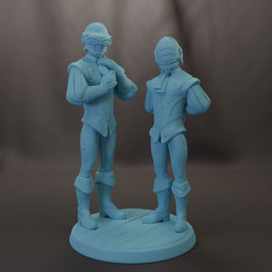two blue figurines standing on a circular base.