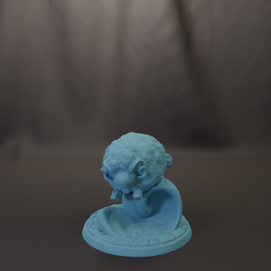 A small blue figurine of a sheep is sitting on a base, with a blurred background.