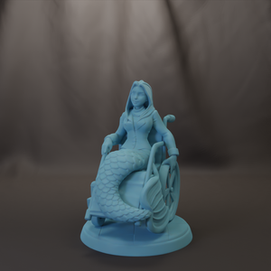 A figurine of a mermaid sitting in a wheelchair, with a dark background.