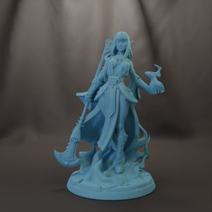 A figurine of a female character with long hair and a flowing robe, holding a weapon and standing on a rock formation.