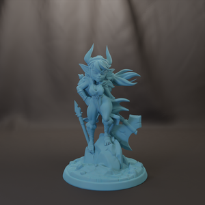 A figurine of a female character with horns and a flowing cape, standing on a rock and holding a weapon.