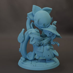 A light blue, whimsical figurine depicting a fantastical creature with a large head and a smaller body, surrounded by various organic elements.