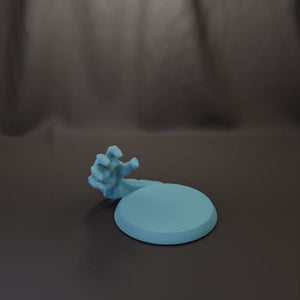 A blue hand-like object is resting on a round, light blue base against a dark background.