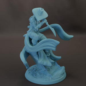 A figurine of a person wearing a hat and holding a sword, standing on a rock.