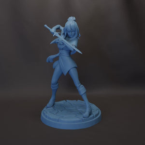 A figurine of a female character with a sword, standing on a platform.