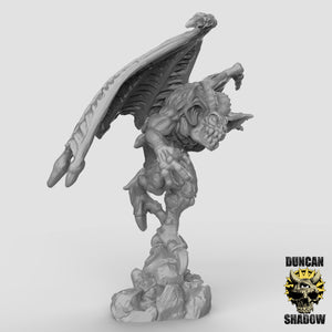 a small statue of a demon with wings